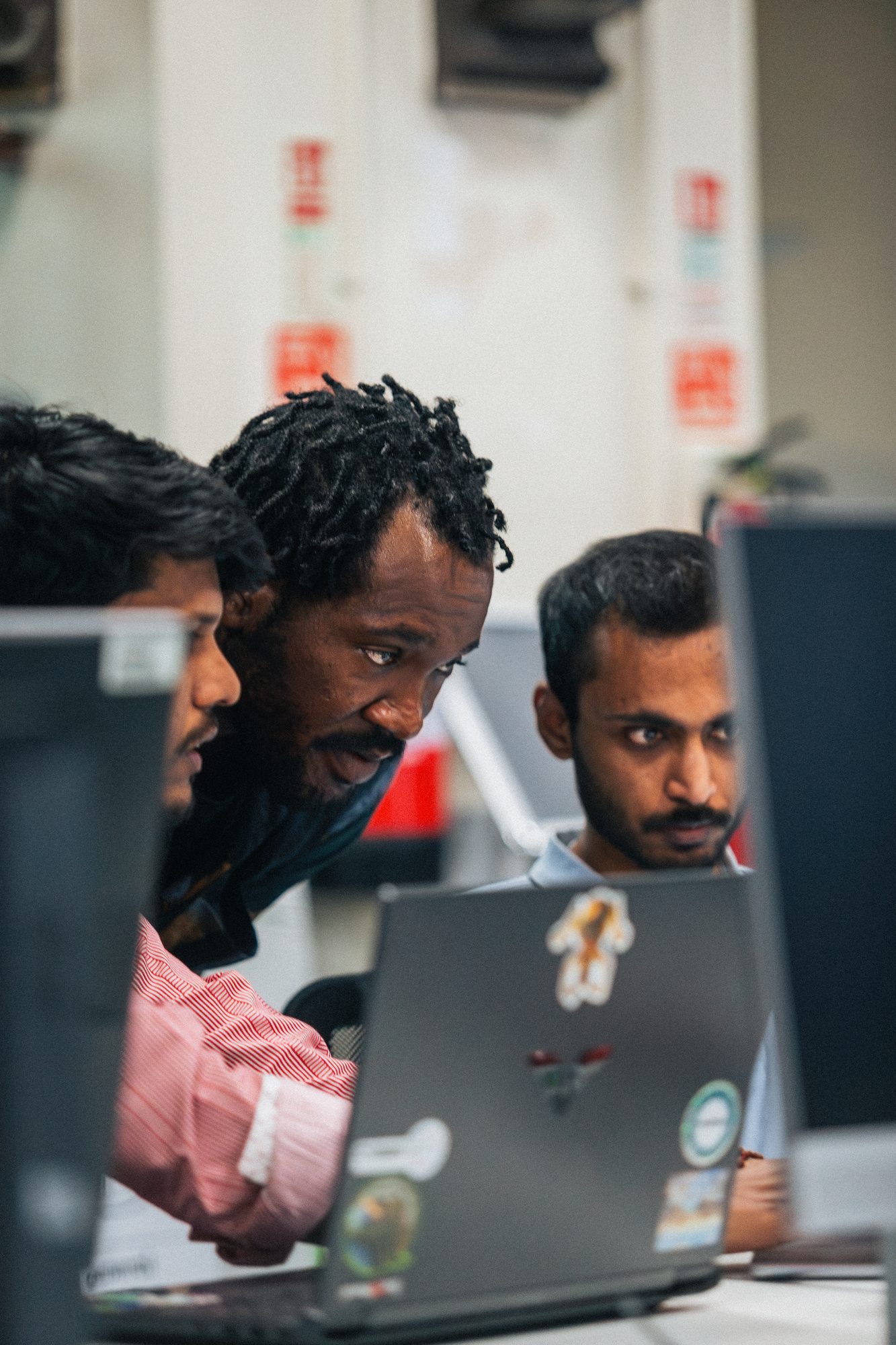 A team gathered around a laptop mid-build