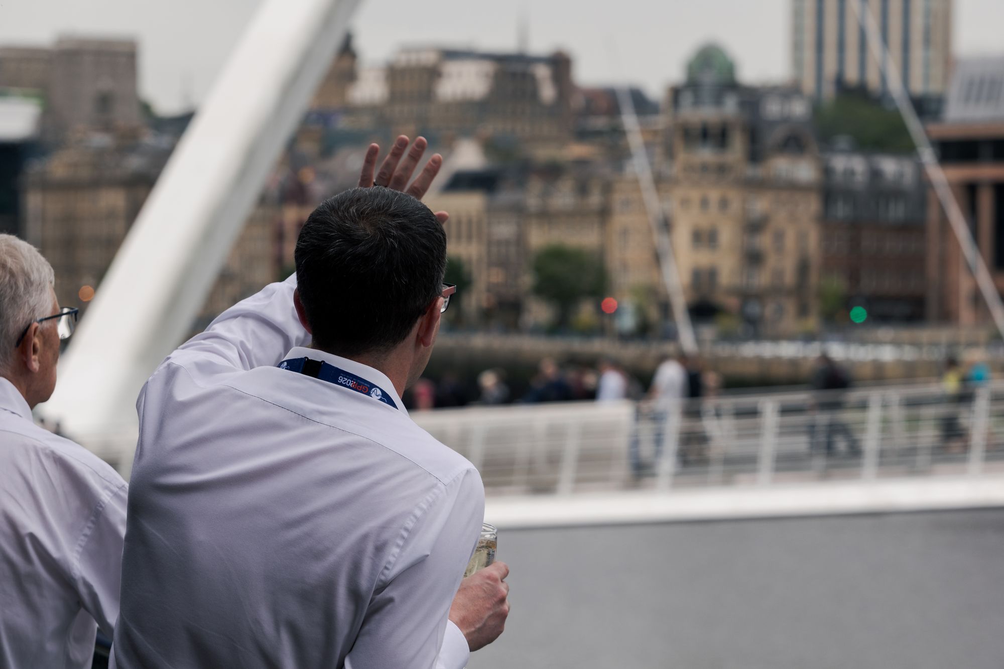 A delegate looking out over the Newcastle quayside and the Millennium Bridge, drink in hand