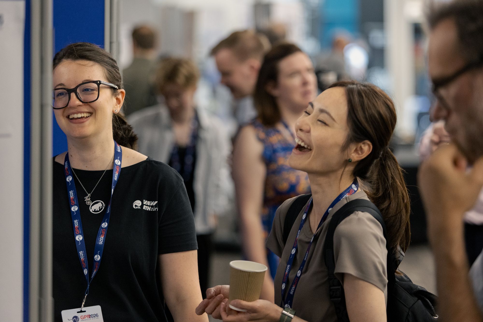 Two delegates sharing a laugh over coffee