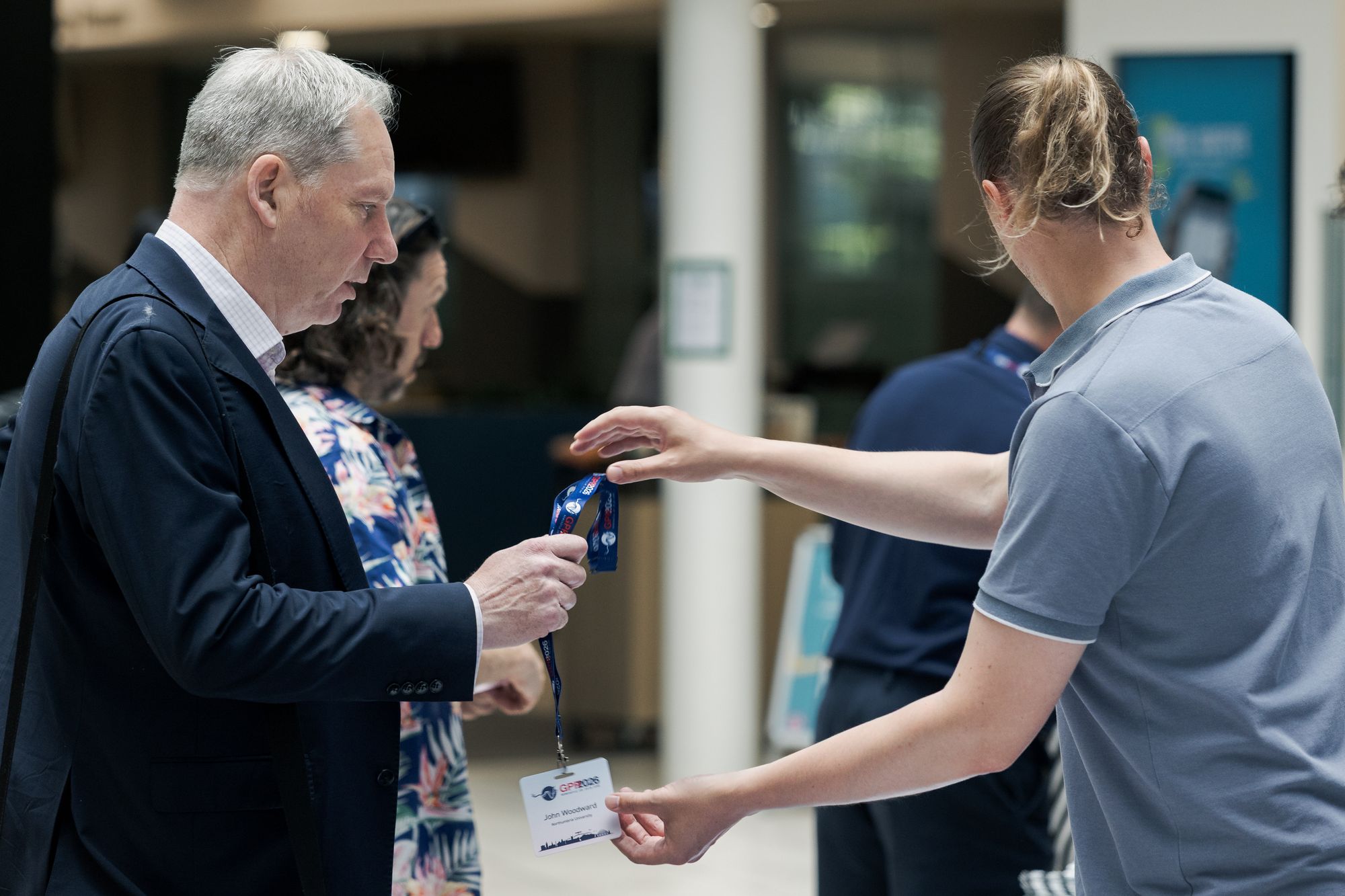 A delegate collecting their conference badge at registration